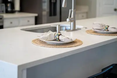 a kitchen counter with two plates and a sink at Disney THEMED HOME, PRIVATE HEATED POOL, COMMUNITY WATERPARK in Orlando