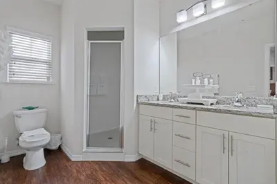 a bathroom with a toilet and a sink and a mirror at Themed Villa, Great Location with proximity to Disney in Kissimmee