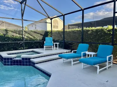 a patio with two chairs and a swimming pool at Four Bed Pool/Spa Home-Windsor Palms Resort in Kissimmee