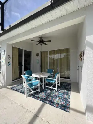 a patio with a table and chairs on a porch at Four Bed Pool/Spa Home-Windsor Palms Resort in Kissimmee