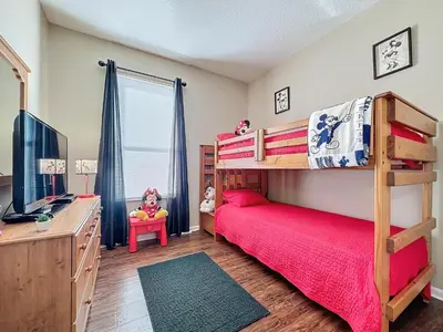 a bedroom with a bunk bed and a desk at Tranquility Palms in a Resort- Steps to Disney in Kissimmee