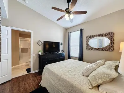 a bedroom with a bed and a ceiling fan at Tranquility Palms in a Resort- Steps to Disney in Kissimmee