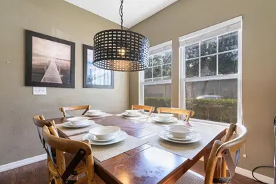 a dining room table with chairs and a chandelier at Casa 4Q c/ Clubhouse – 10 Min da Disney in Kissimmee