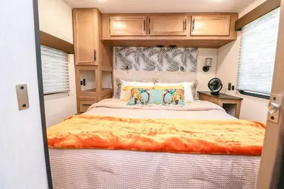 a bedroom with a large bed in an rv at FunTropicalTinyHomeGolfCartLake in Orlando