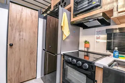 a kitchen with a stove and a refrigerator at FunTropicalTinyHomeGolfCartLake in Orlando