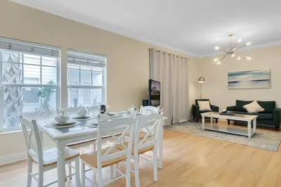 a dining room and living room with a table and chairs at Casa 4Q + Sala de Jogos – 15 min da Disney in Kissimmee