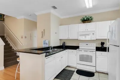 a kitchen with white cabinets and a white appliances at Casa 4Q + Sala de Jogos – 15 min da Disney in Kissimmee