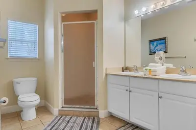 a bathroom with a toilet and a sink and a mirror at Casa 4Q + Sala de Jogos – 15 min da Disney in Kissimmee