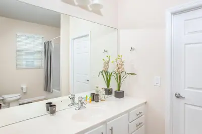 a white bathroom with a sink and a mirror at Dream 4814 Condo At Vista Cay in Orlando