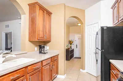a kitchen with wooden cabinets and a black refrigerator at Dream 4814 Condo At Vista Cay in Orlando