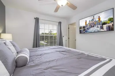 a bedroom with a large bed with a tv on the wall at Beautiful Townhouse In Bella Vida Resort in Kissimmee