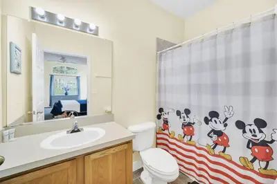 a bathroom with a sink and a toilet and a mirror at Townhome Perfectly Located Near Clubhouse in Kissimmee