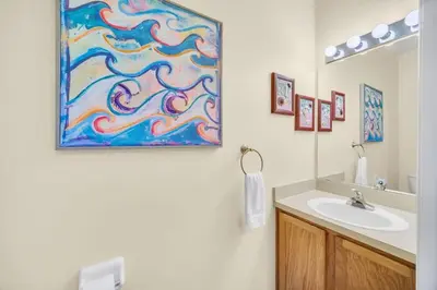 a bathroom with a sink and a painting on the wall at Townhome Perfectly Located Near Clubhouse in Kissimmee