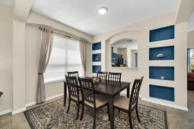 a dining room with a black table and chairs at Remodeled 7 Bedroom Retreat Near Disney World in Kissimmee