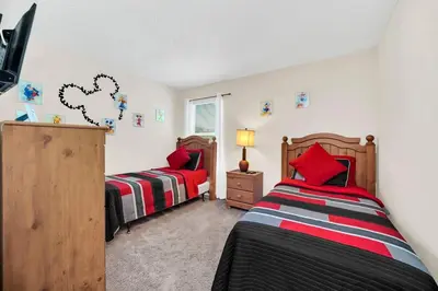 a bedroom with two beds and a tv in it at Remodeled 7 Bedroom Retreat Near Disney World in Kissimmee