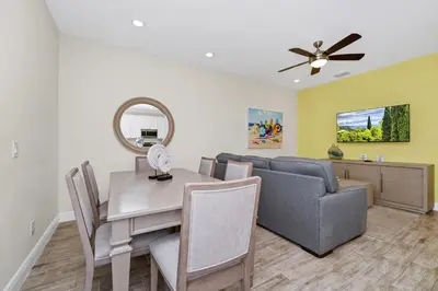 a dining room and living room with a table and a couch at Colorful Villa Near Disney With Margaritaville Resort & Island H20 Waterpark Access - 3197Cs in Orlando