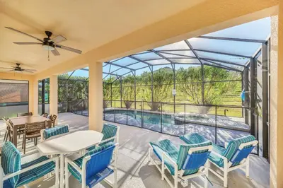 a patio with a table and chairs and a view of a pool at Emerald Island Resort 6 bedroom 4 bathroom luxury in Kissimmee