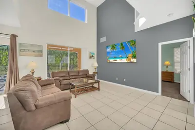 a living room with two couches and a table at Emerald Island Resort 6 bedroom 4 bathroom luxury in Kissimmee