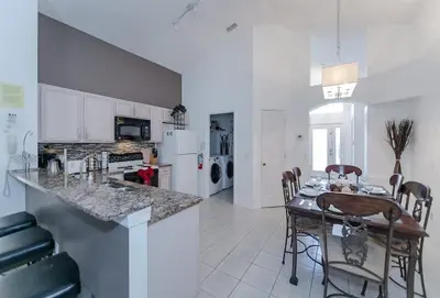 a kitchen and dining room with a table and chairs at Beautiful Pool Home by Disney World in Orlando