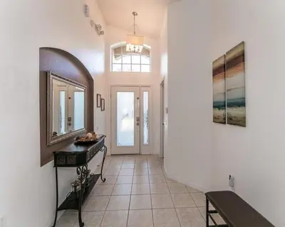a hallway with a mirror and a table and a mirror at Beautiful Pool Home by Disney World in Orlando