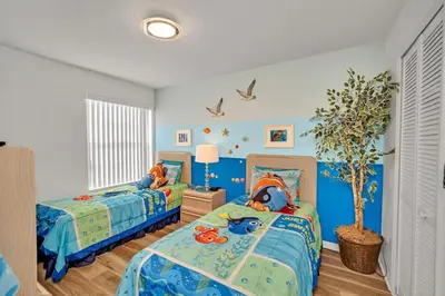 a bedroom with two beds and a tree in it at Beautiful Royal Palm Bay Condo near Disney in Kissimmee