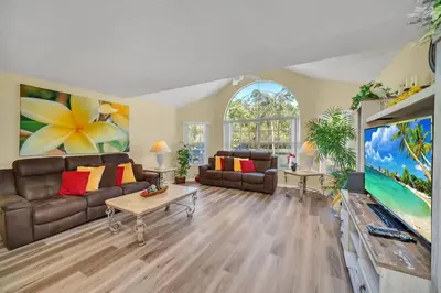 a living room with a couch and a tv at Beautiful Royal Palm Bay Condo near Disney in Kissimmee