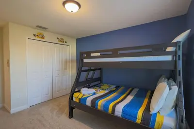 a bedroom with a bunk bed with a blue wall at Magical Townhome private pool in Storey Lake in Kissimmee