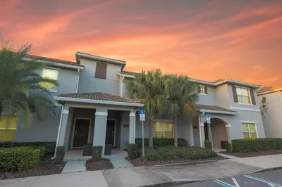 a house with palm trees in front of a sunset at Magical Townhome private pool in Storey Lake in Kissimmee
