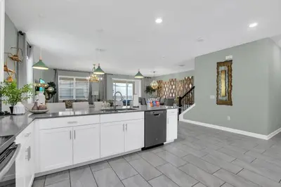 a large kitchen with white cabinets and a tile floor at Storey Lake Dream Villa with Private Pool in Kissimmee