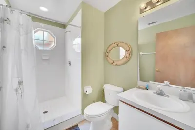 a bathroom with a toilet and a sink and a mirror at Incredible Island Club Villa Condo in Kissimmee
