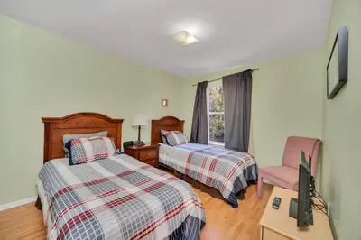 a bedroom with two beds and a tv and a chair at Incredible Island Club Villa Condo in Kissimmee