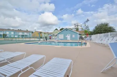 a swimming pool with lounge chairs and a tennis court at Incredible Island Club Villa Condo in Kissimmee