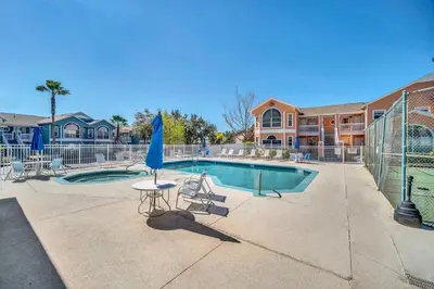 a swimming pool with a table and a blue umbrella at Incredible Island Club Villa Condo in Kissimmee