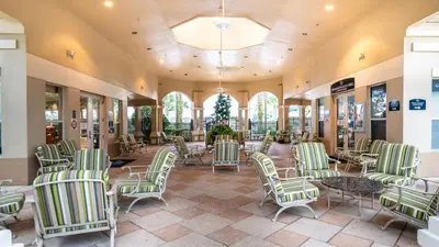 a lobby with green and white chairs and tables at 3 Bedrooms Condo Only Minutes From Disney in Orlando