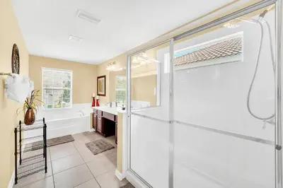 a bathroom with a shower and a sink and a tub at Windsor Hills Dream Private Screened Pool Home in Orlando