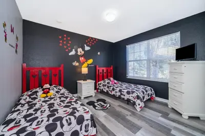 a bedroom with two beds and a wall with a mickey mouse mural at Luxury 6 Bedroom Pool Home in Windsor Hills in Orlando