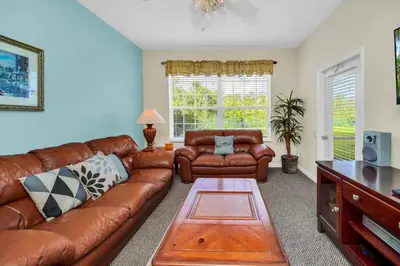 a living room with a leather couch and a table at 3 Bedroom 2 Bath Condo in Windsor Palms Resort in Kissimmee