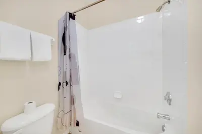 a white bathroom with a shower and a toilet at 3 Bedroom 2 Bath Condo in Windsor Palms Resort in Kissimmee