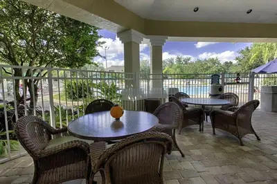 a patio with tables and chairs and a fence at 3 Bedroom 2 Bath Condo in Windsor Palms Resort in Kissimmee