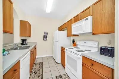 a kitchen with white appliances and wooden cabinets at 3 Bedroom 2 Bath Condo in Windsor Palms Resort in Kissimmee
