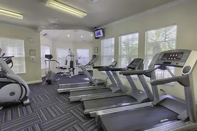 a fitness room with treadmills and elliptical machines at Beautiful Vacation Condo at Windsor Palms Resort in Kissimmee