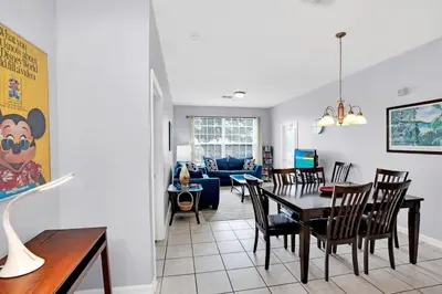 a dining room and living room with a table and chairs at Beautiful Vacation Condo at Windsor Palms Resort in Kissimmee