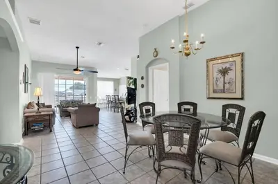 a dining room and living room with a table and chairs at Windsor Palms Villa with Very Private Pool in Kissimmee