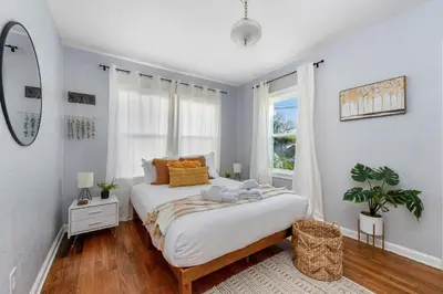 a white bedroom with a large bed and a window at Tiny Home w MIL suite - 3 MI to DT in Orlando