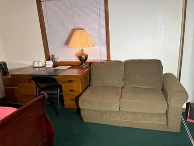 a living room with a couch and a desk with a lamp at Red Brick House in Kissimmee
