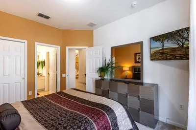 a bedroom with a bed and a tv on the wall at Olivia's Dream Villa on WindsorHills in Orlando