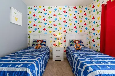 two beds in a bedroom with blue and white sheets at Casa 4Q Lucaya com Temas Disney e Clubhouse in Kissimmee