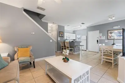 a living room with a couch and a table at Casa 4Q Lucaya com Temas Disney e Clubhouse in Kissimmee