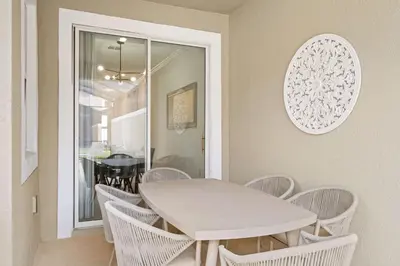 a white dining room with a white table and chairs at Stunning home at Storey Lake close to Disney in Kissimmee