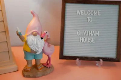 a figurine of a man and a pink flamingo next to a sign at Chatham House in Kissimmee